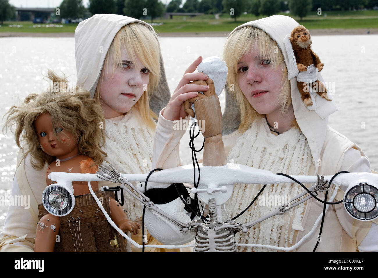 Deux adolescents de robes blanches avec des animaux en peluche et de poupées représentant des personnages de fantaisie, d'étranges costumes, maquillage blanc, cosplayeurs Banque D'Images