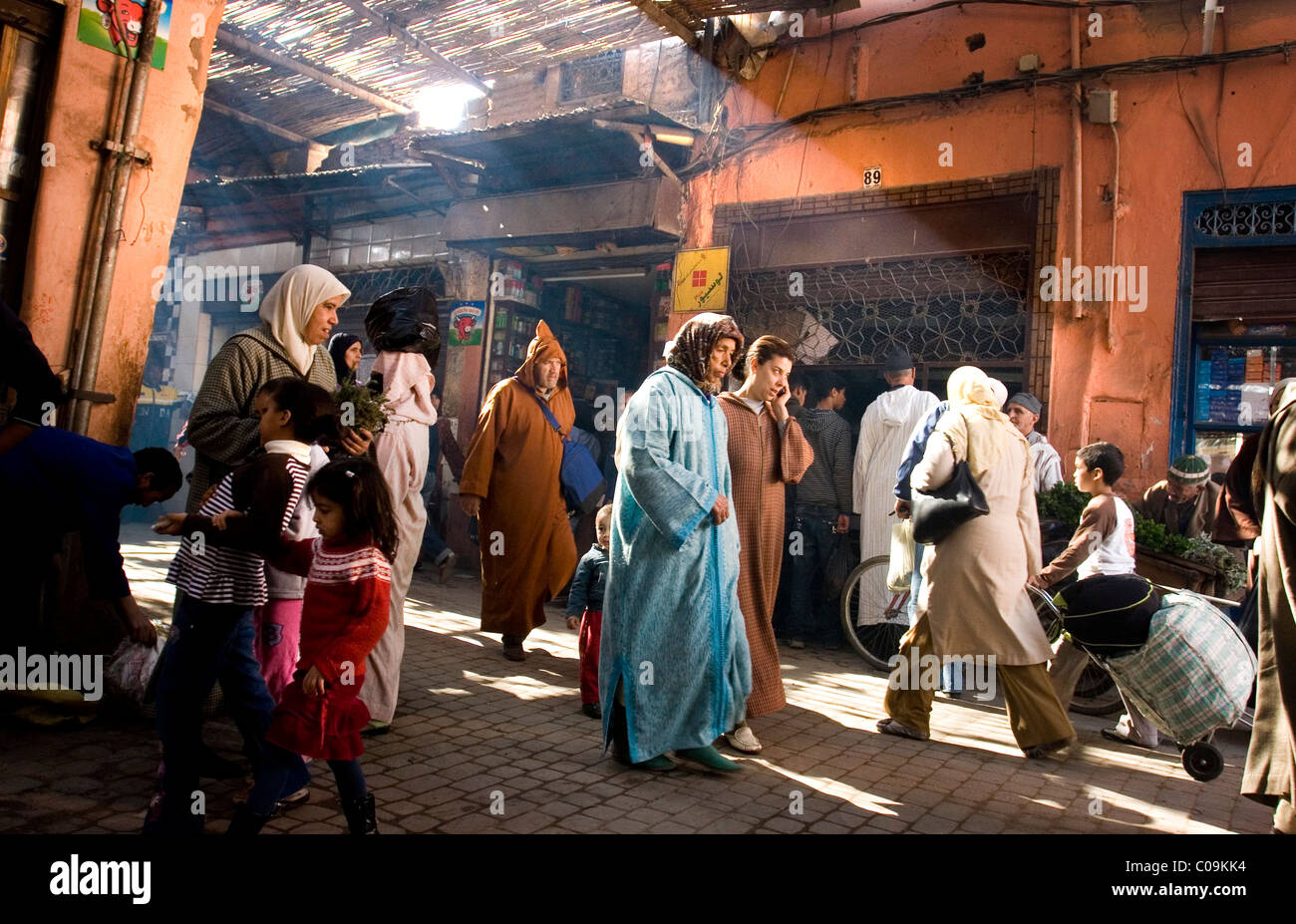 Les piétons marcher dans une rue pavée de Marrakech, Maroc, en Afrique du Nord. Banque D'Images