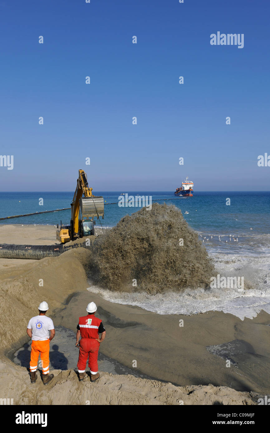 Drague par un flexible de pompage du sable sur une plage pour les plages ou la régénération des plages, Platja de Barceloneta, Barcelone Banque D'Images