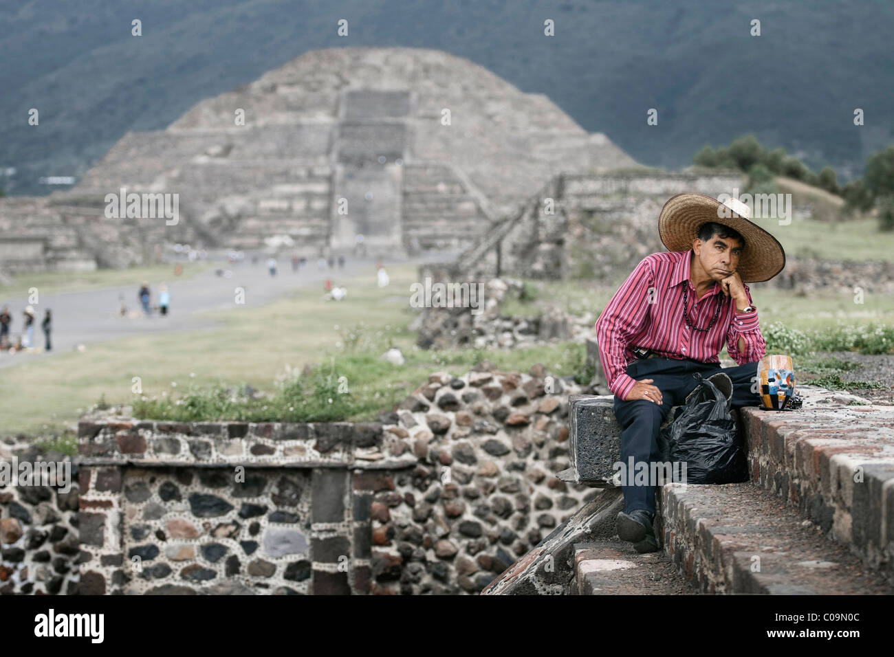 Un homme avec un grand chapeau assis avec la lune pyramide sur son dos à Teotihuacan, État de Mexico, Mexique. Banque D'Images
