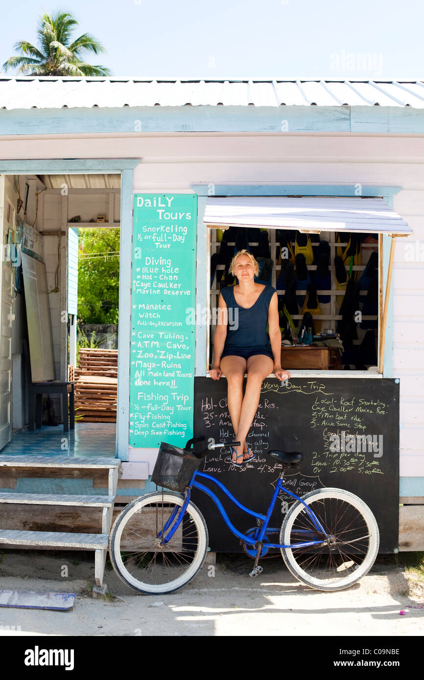 Une femme se trouve dans la fenêtre d'un magasin de plongée sur une île dans les Caraïbes. Banque D'Images