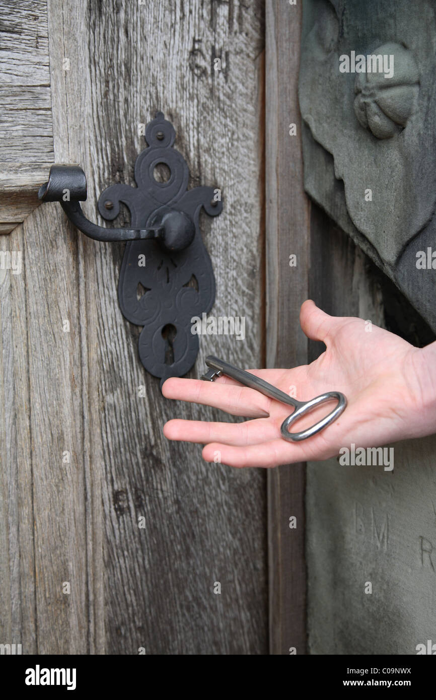 Key lying in ouvrez Palm d'une part prêts à ouvrir un vieux chêne massif porte du château de Kronborg château renaissance avec un énorme key Banque D'Images