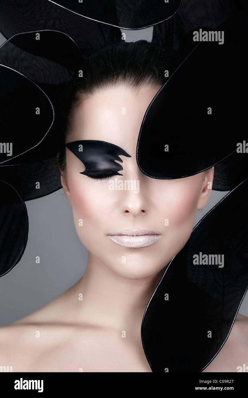 Jeune femme avec des make-up, encadrée de noir de pétales de fleur stylisée, portrait Banque D'Images