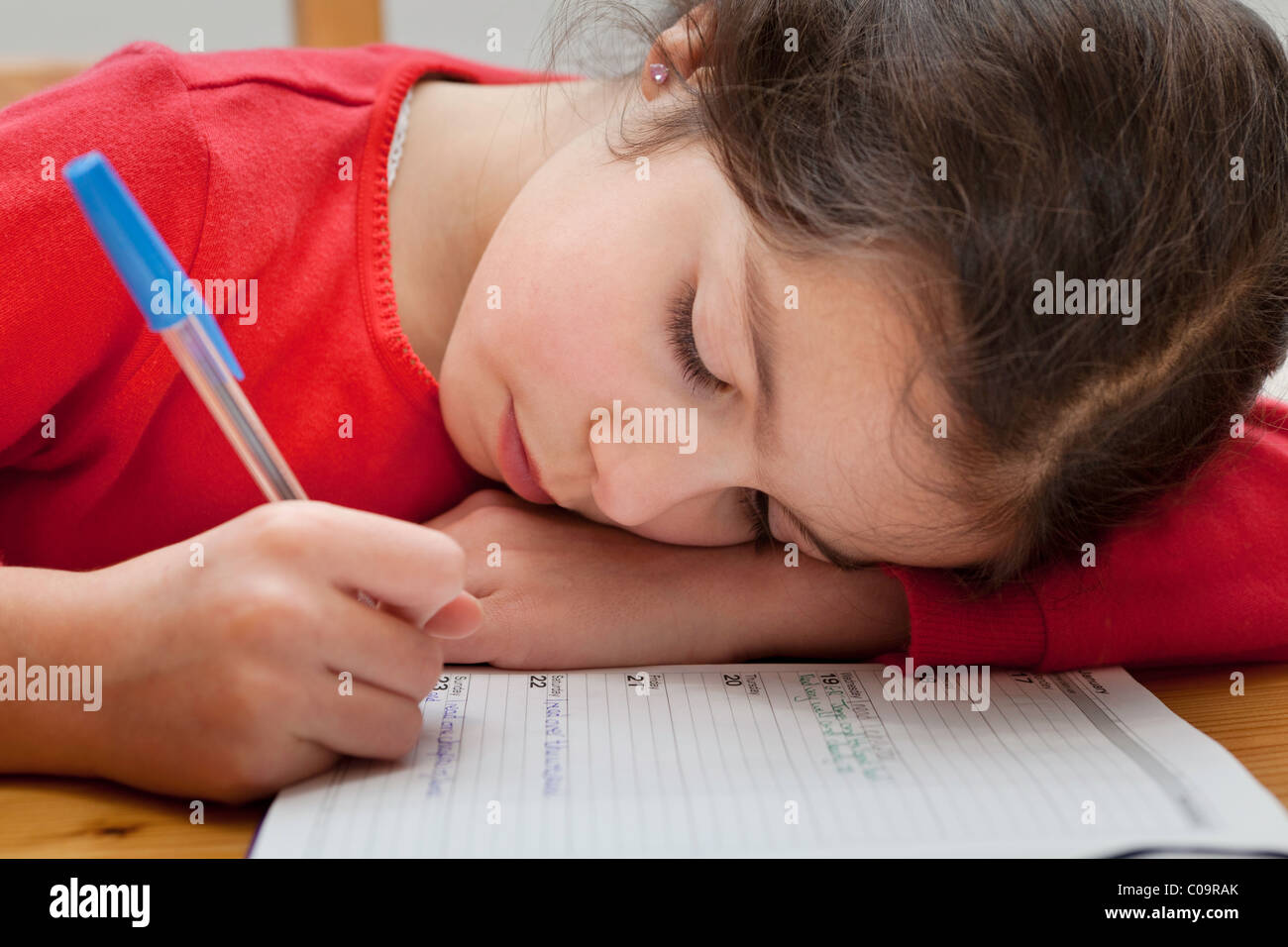 Fille de l'école écrit dans son journal Banque D'Images