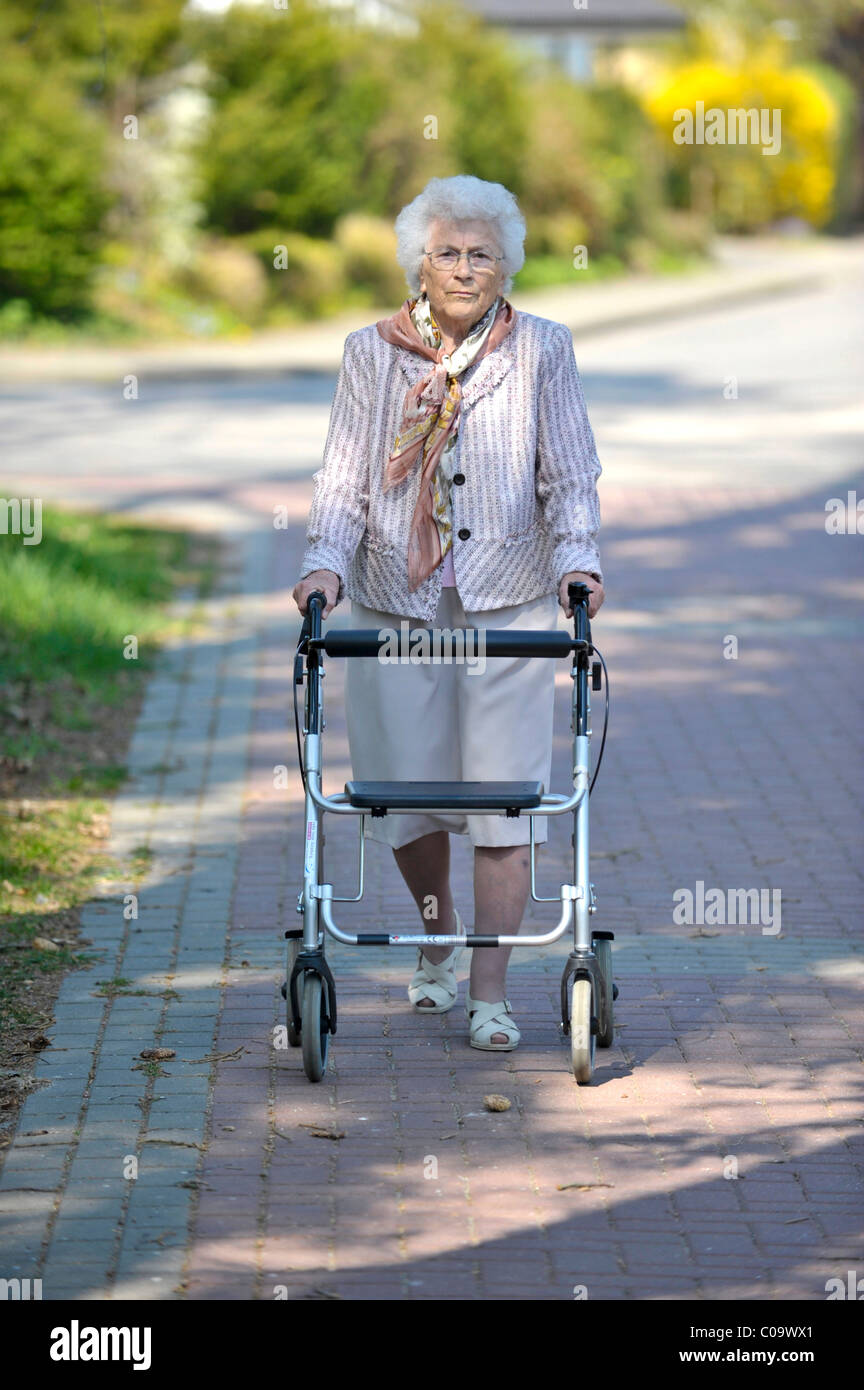 Senior woman marcher avec un déambulateur Banque D'Images