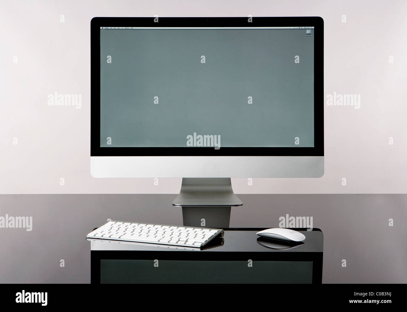 L'ordinateur sans fil moderne avec clavier et souris, isolé sur un bureau  en verre avec un fond gris,vue avant écran gris Photo Stock - Alamy