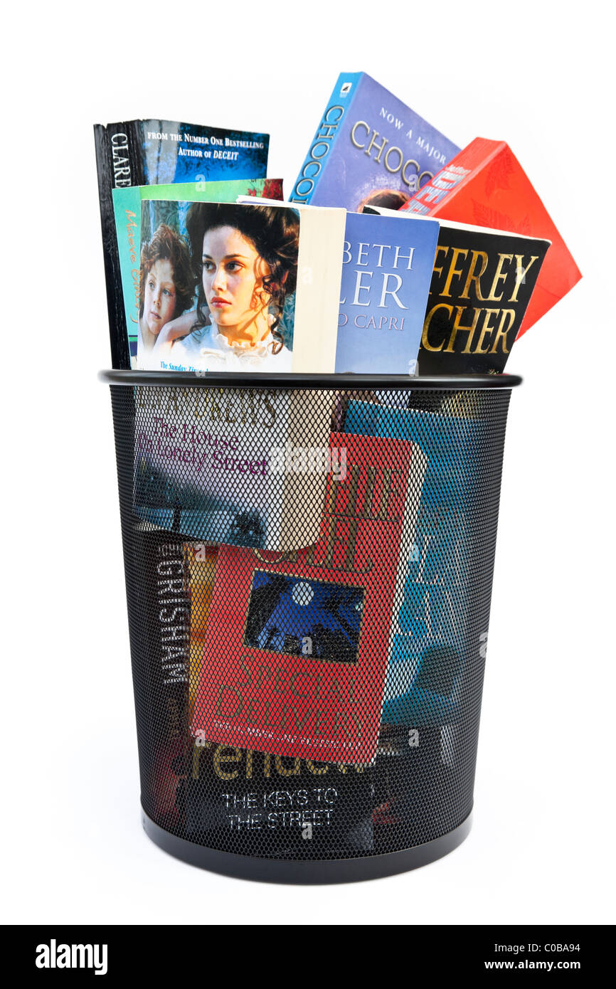 Des livres de poche jeté dans une corbeille à papier bin pour illustrer le changement de concept d'ebooks. England UK Banque D'Images