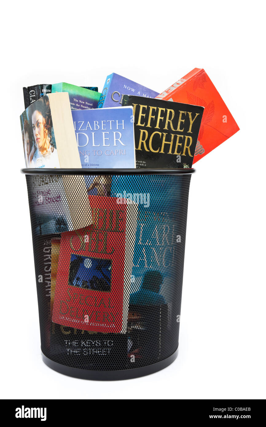 Des livres de poche jeté dans une corbeille à papier bin pour illustrer l'évolution des habitudes de lecture concept. Angleterre Royaume-uni Grande-Bretagne Banque D'Images