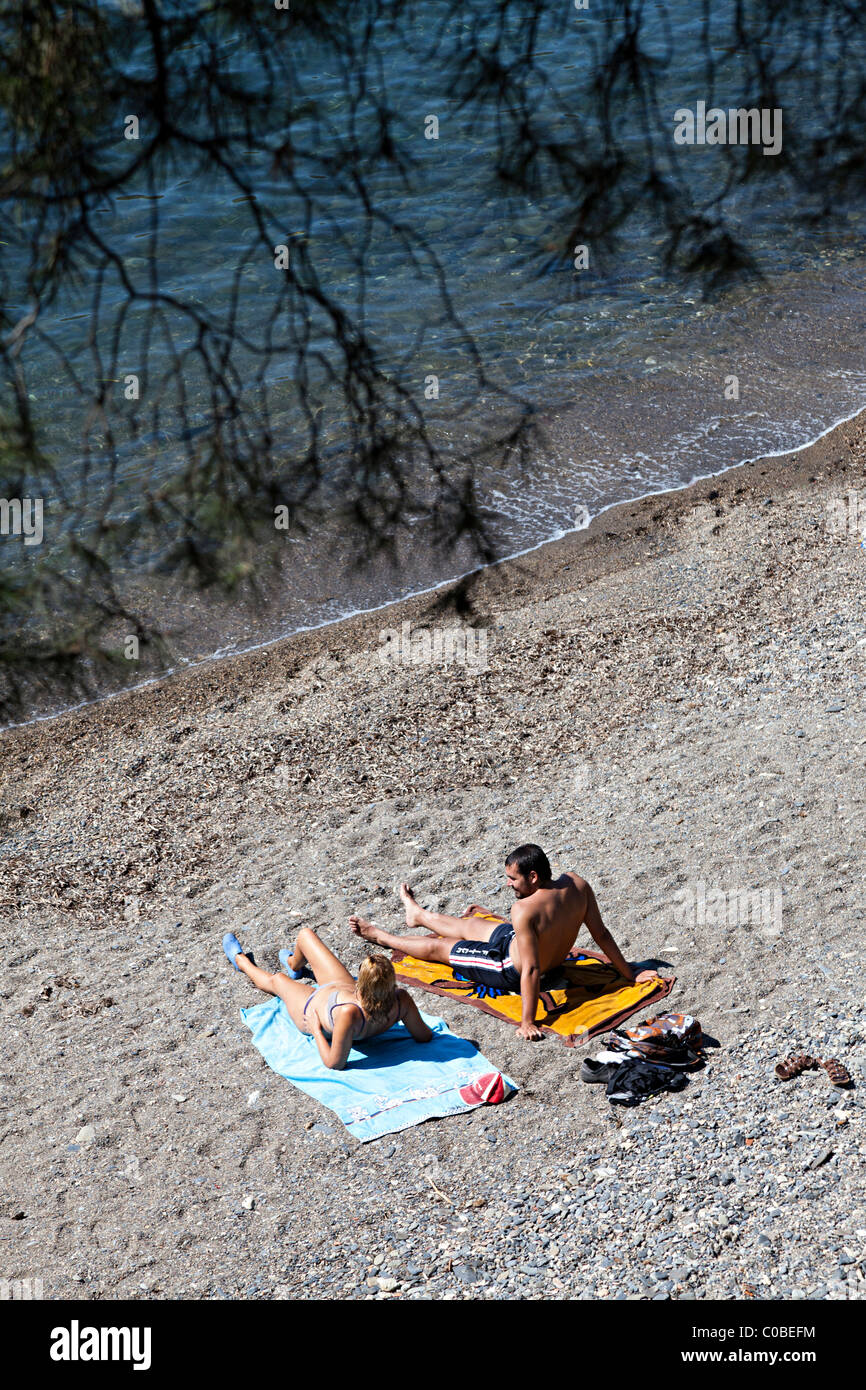 Deux personnes en train de bronzer sur une plage Cala Montjoi Parc naturel de Cap de Creus Emporda Catalogne Espagne Banque D'Images