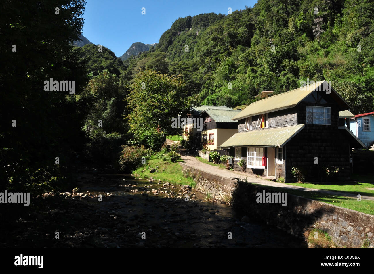 Andes vue montagnes de Rocky River, Swiss-Alpine homes et le chemin d'ascension des montagnes de vert forêt, Peulla, Chili Banque D'Images