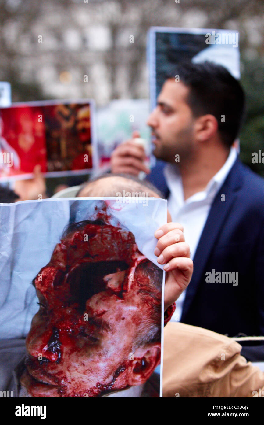 Contenu graphique. Manifestants devant l'ambassade du Bahreïn à Londres faire des photos des morts de l'agitation dans leur patrie Banque D'Images