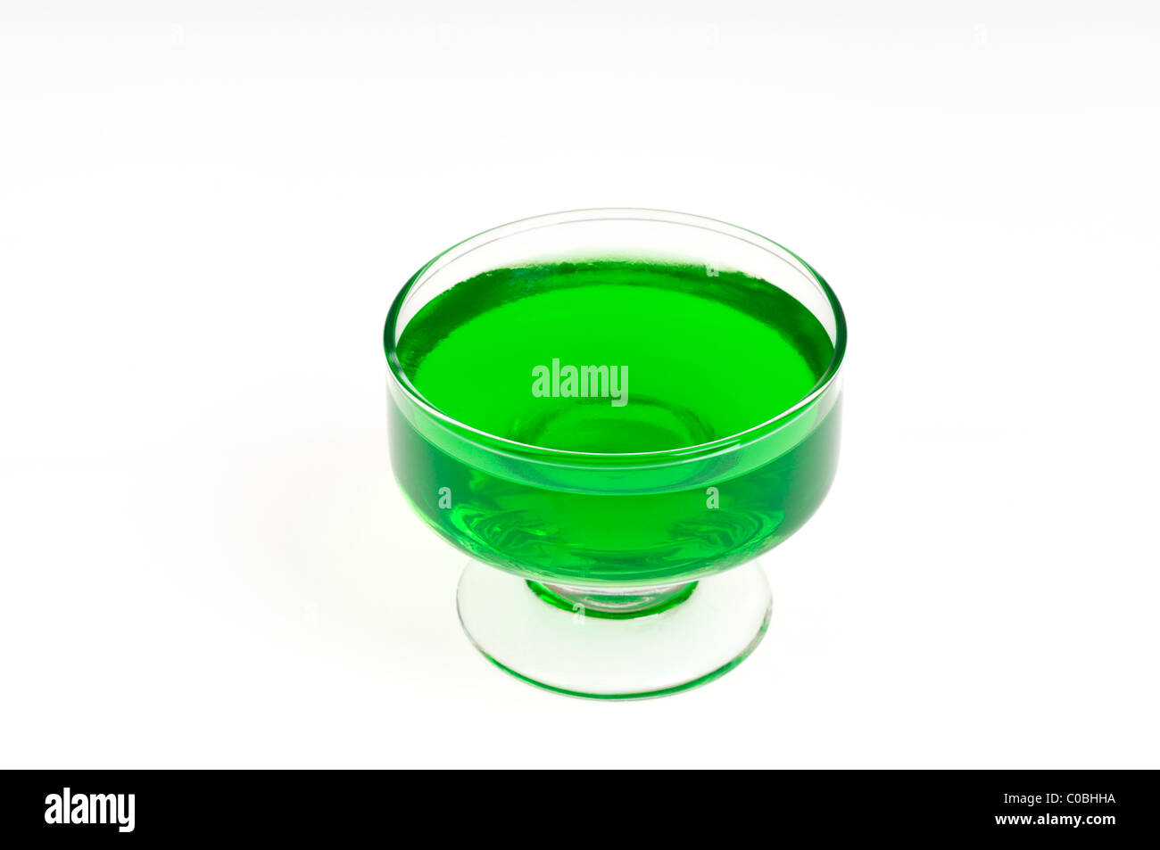 Jell-O citron vert dans le verre plat de service sur fond blanc, découpe. Banque D'Images