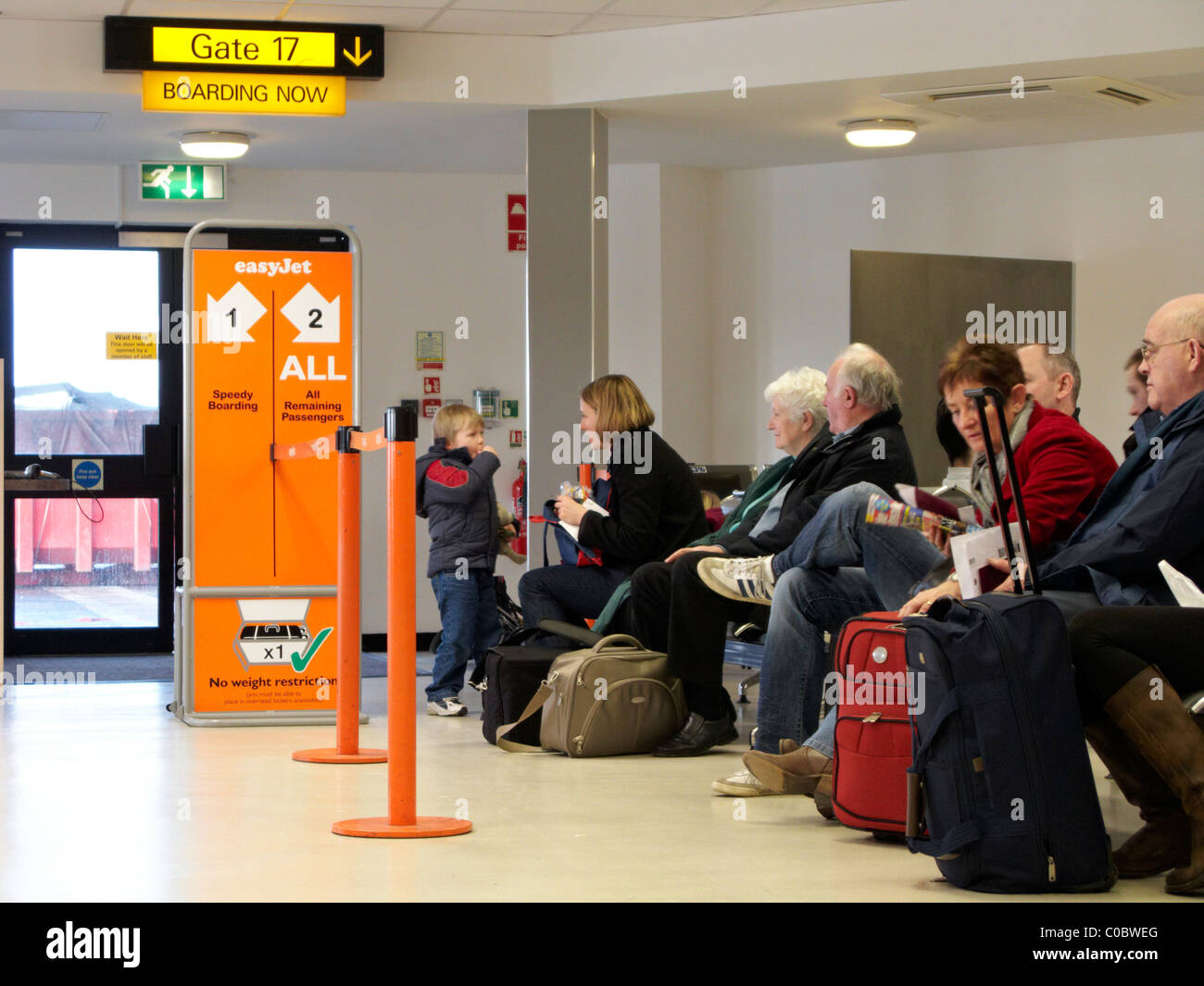 Les passagers assis en attente en attente à la porte d'easyjet à l'aéroport international de Belfast en Irlande du Nord Banque D'Images
