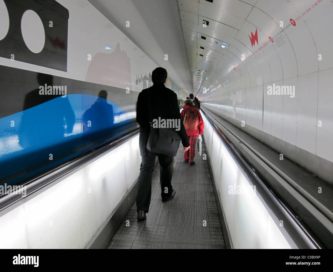 Paris, France, les gens sur le trottoir en mouvement à l'intérieur du couloir de métro, la gare Montparnasse, les passagers du métro parisien, la solitude. Image conceptuelle de la solitude représentée par la silhouette d'un homme marchant dans un couloir Banque D'Images