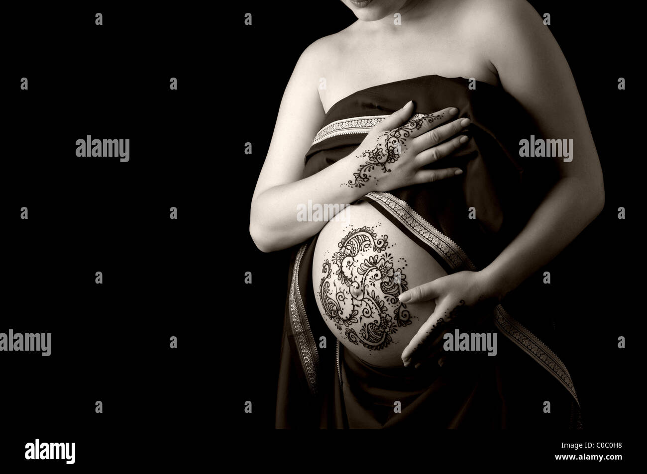 Un b&w photo de henné appliqué à un ventre de la femme enceinte et les mains. Banque D'Images