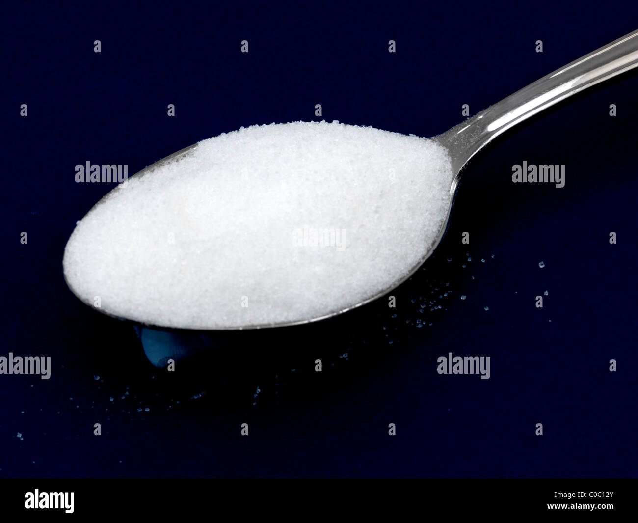 Sucre blanc sur un fond bleu cuillère Banque D'Images