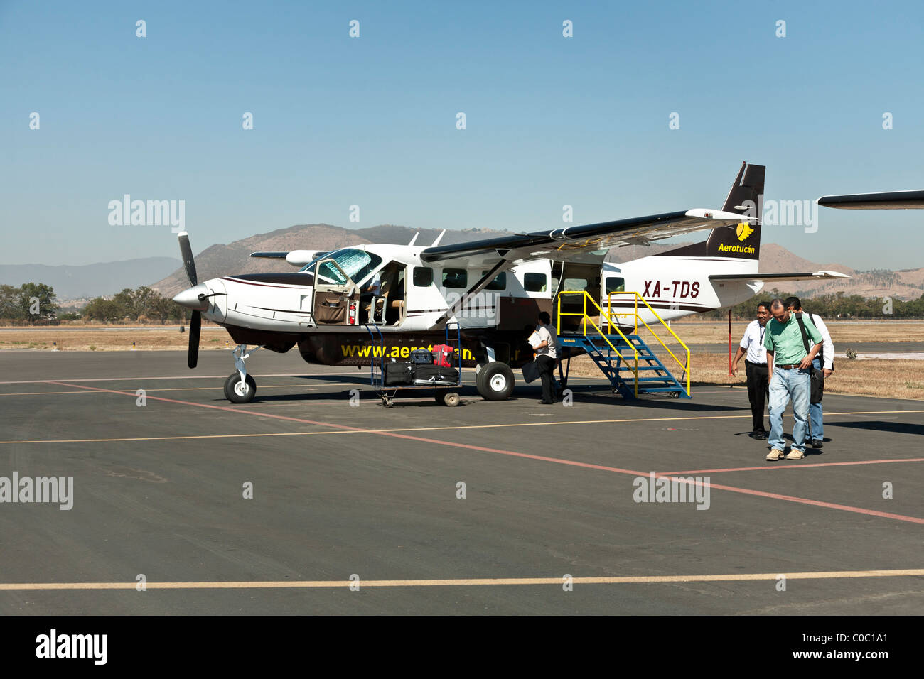 Les passagers quitter un avion Cessna passager 12 Aerotucan la vieille manière mode voyage tarmac de l'aéroport d'Oaxaca l'état d'Oaxaca au Mexique Banque D'Images