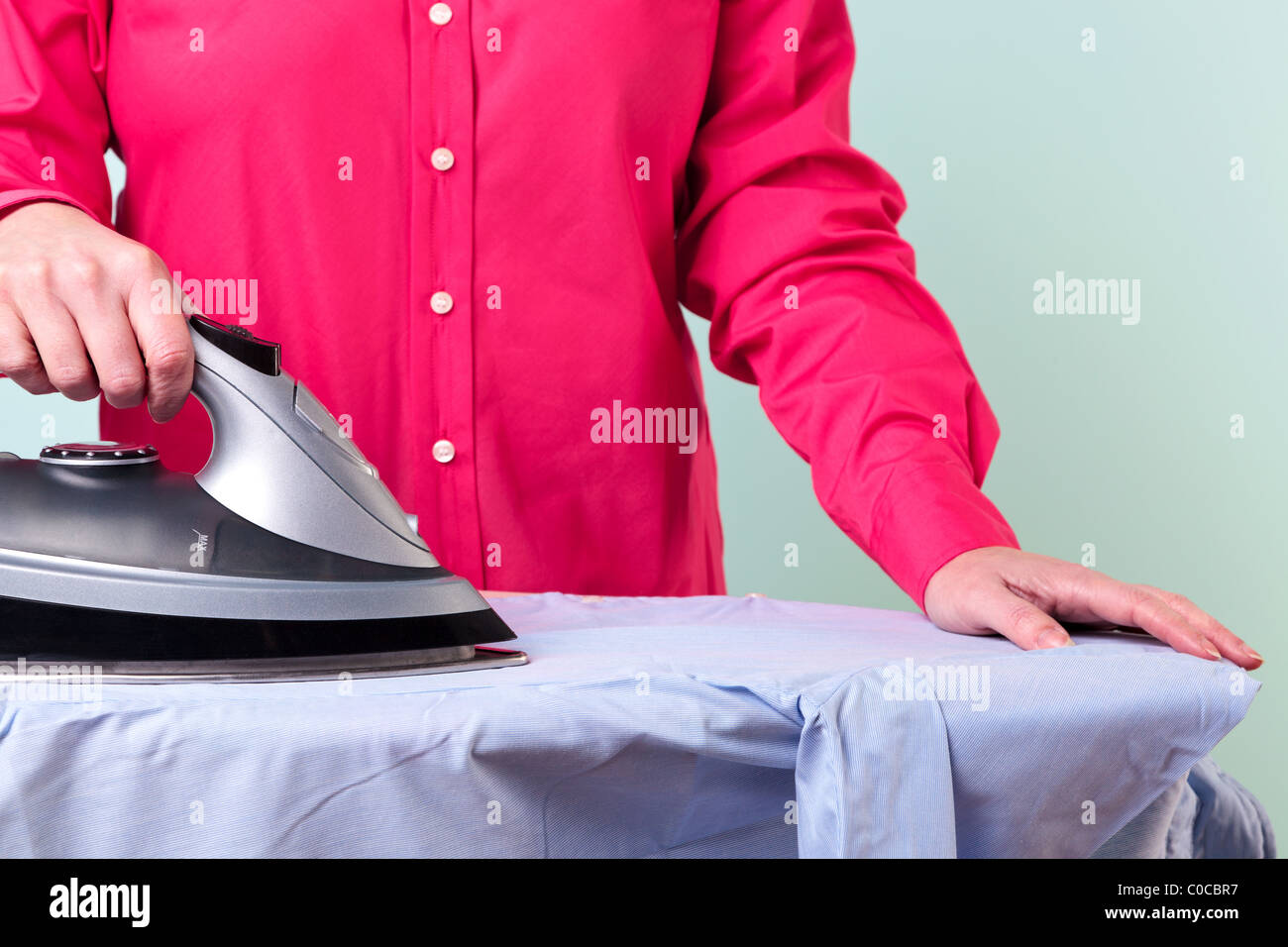 Photo d'une femme un repassage chemise de travail avec un fer à vapeur  Photo Stock - Alamy