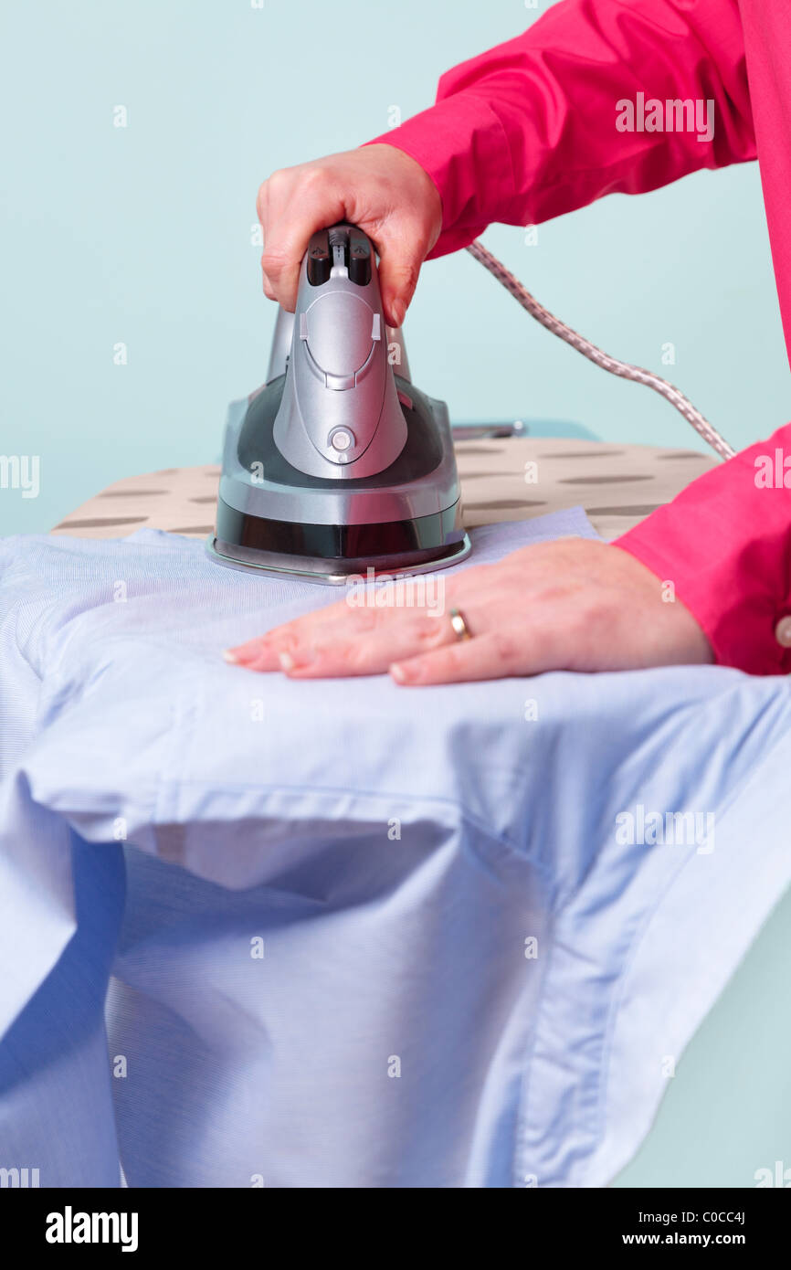 Photo d'une femme un repassage chemise de travail avec un fer à