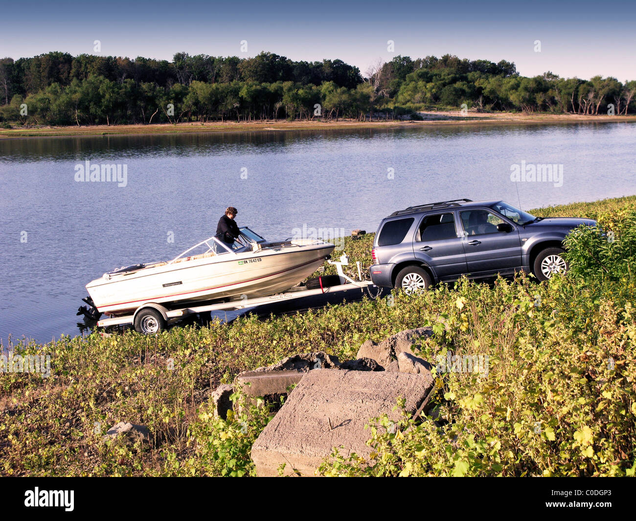 Une femme se prépare à mettre son bateau à l'eau d'un lac dans la région de New York, USA. Banque D'Images