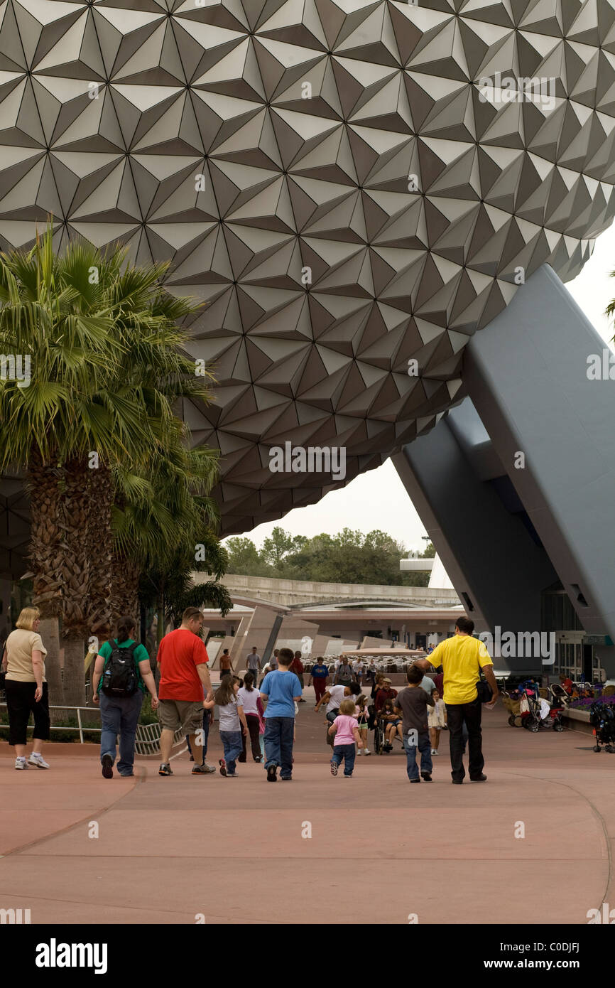 Les visiteurs marchent sous la très reconnaissable Spaceship Earth à Epcot sphère géodésique dans le parc à thème Disney World, Orlando, Floride. Banque D'Images