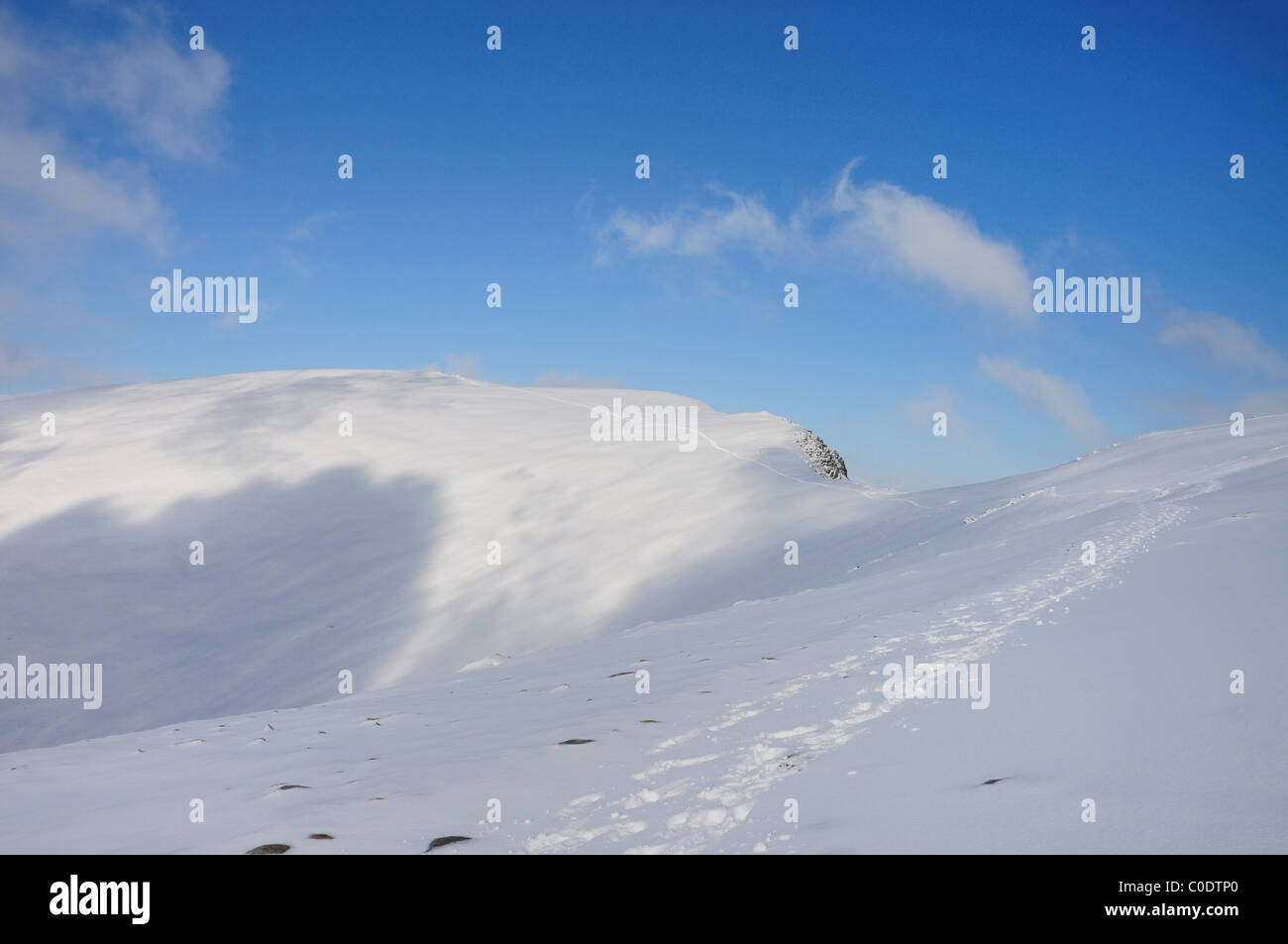 Des traces de pas dans la neige sur l'approche du sommet de Helvellyn en hiver dans le Lake District Banque D'Images
