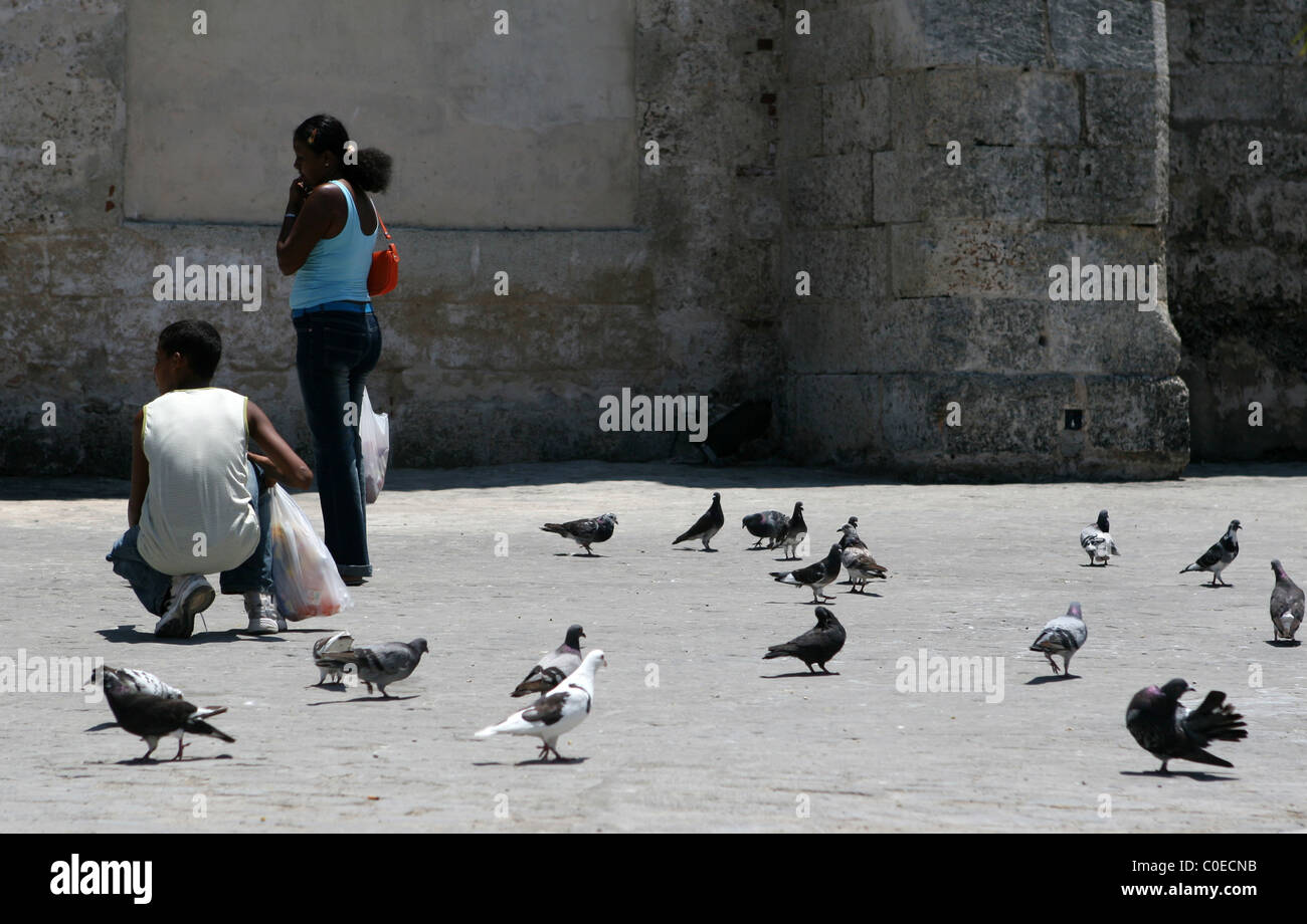 L'alimentation des Cubains en dehors des pigeons couvent et l'église San Francisco de Asis, sur la Plaza de San Francisco La Havane, Cuba. Banque D'Images