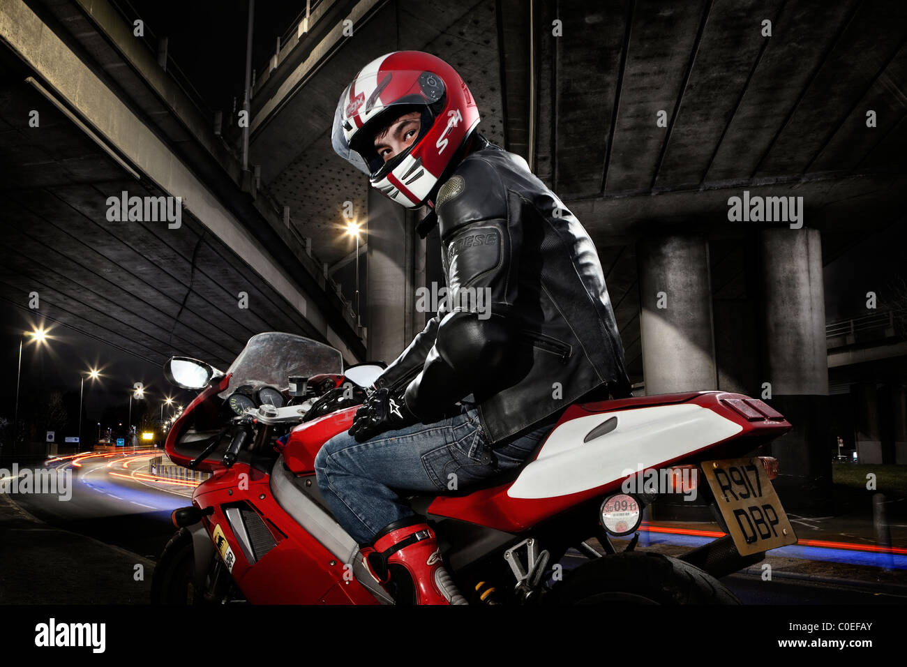 Portrait d'un jeune homme sur une moto rouge Banque D'Images