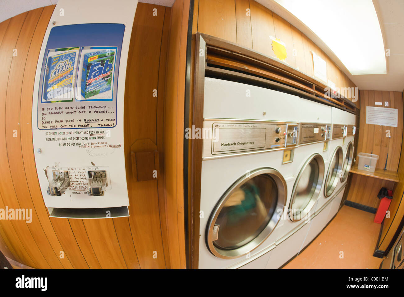 Un distributeur automatique de la lessive dans une laverie avec séchoirs  commerciaux montrant le mouvement comme ils tournent en arrière-plan le  Royaume-Uni Photo Stock - Alamy