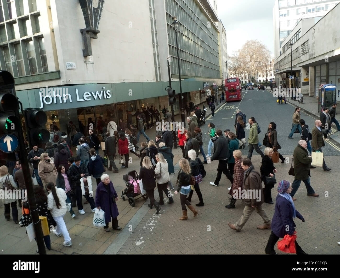 High street shopping et les piétons circulant à l'extérieur de l'entrée de John Lewis magasin sur Oxford Street à Londres, Angleterre Royaume-uni KATHY DEWITT Banque D'Images
