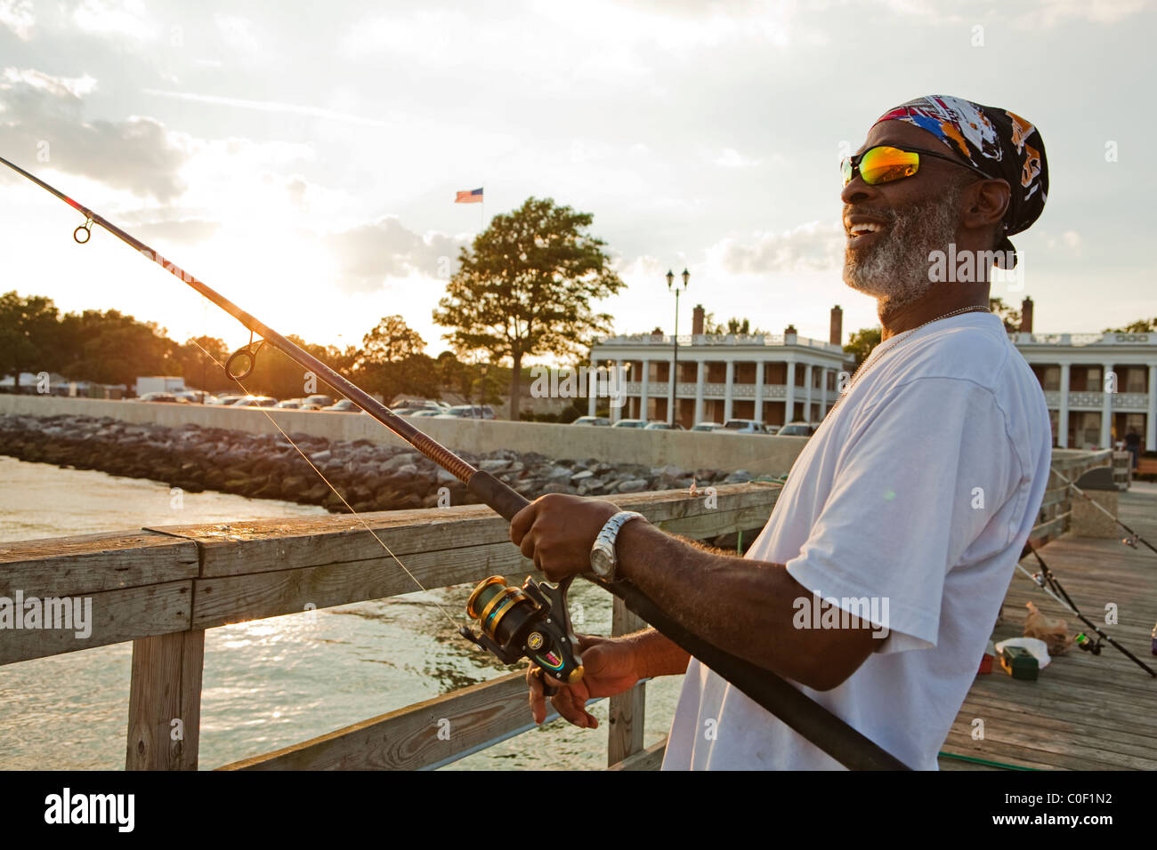 Un homme la pêche au large de la jetée de la communauté à Fort Monroe Banque D'Images
