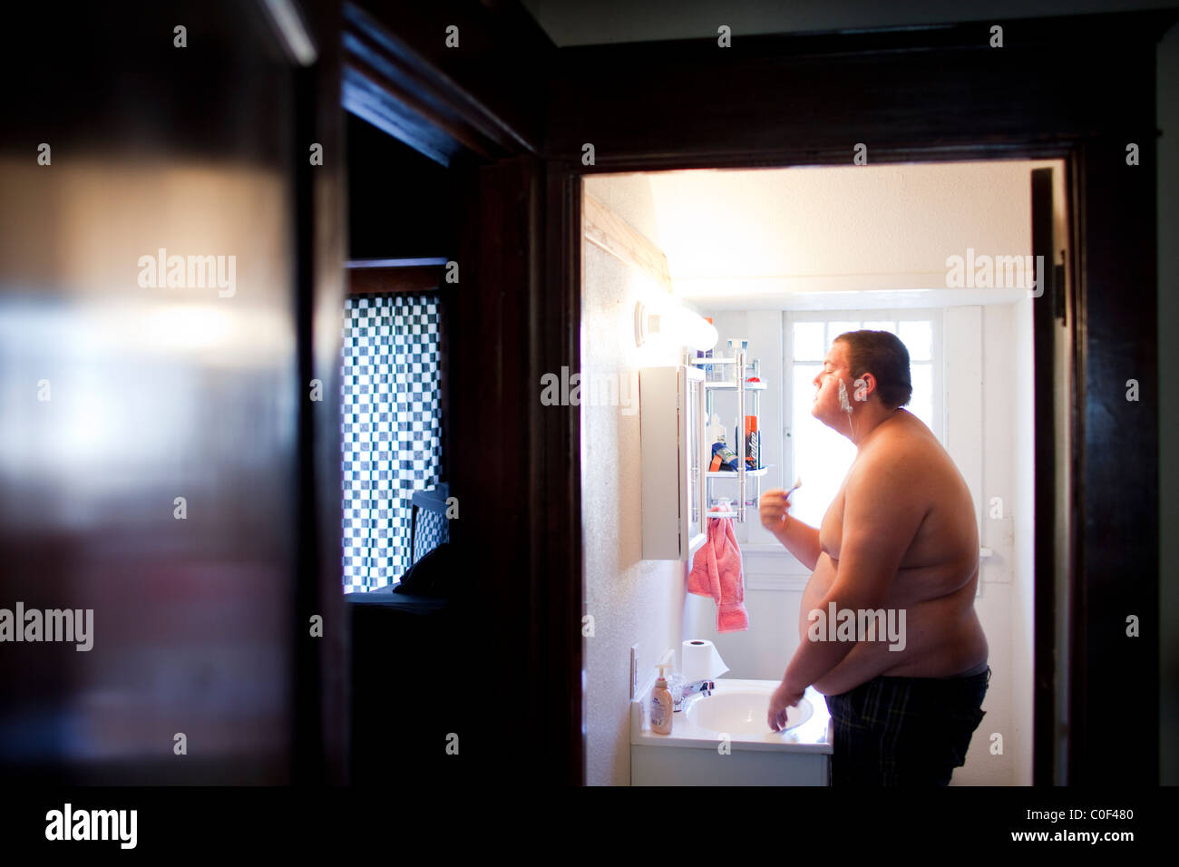 La Grange, California, United States. Un adolescent obèse se rase à la maison. Banque D'Images