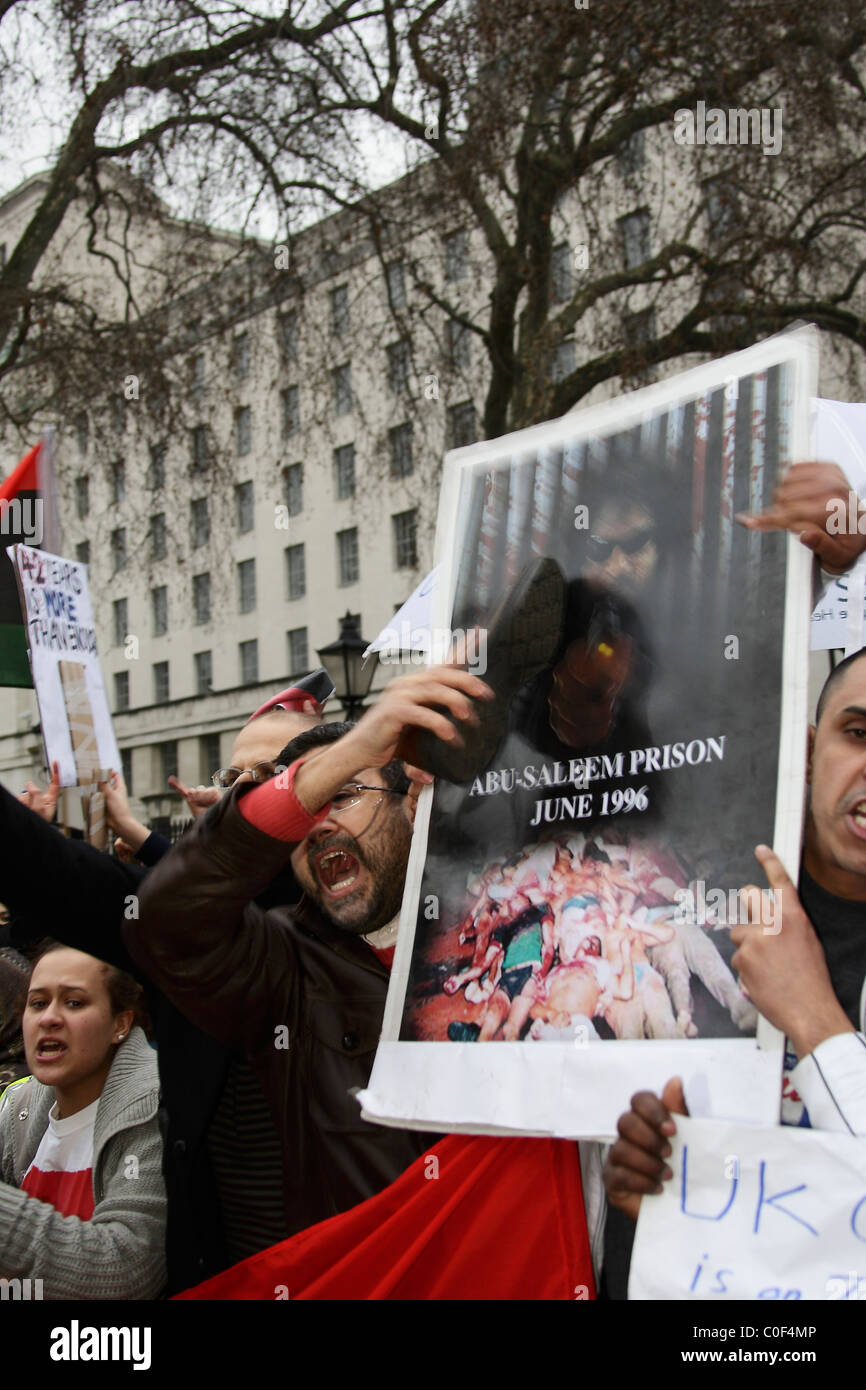 Manifestant libyen hits une affiche avec sa chaussure au cours de protestation libyen à Downing Street Banque D'Images