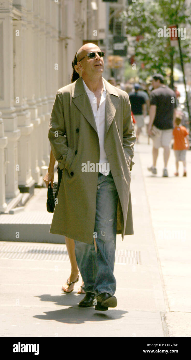 Bruce Willis porte un vieux manteau de pluie mackintosh et sa petite amie  modèle britannique, Emma Heming portant une robe d'été légère Photo Stock -  Alamy