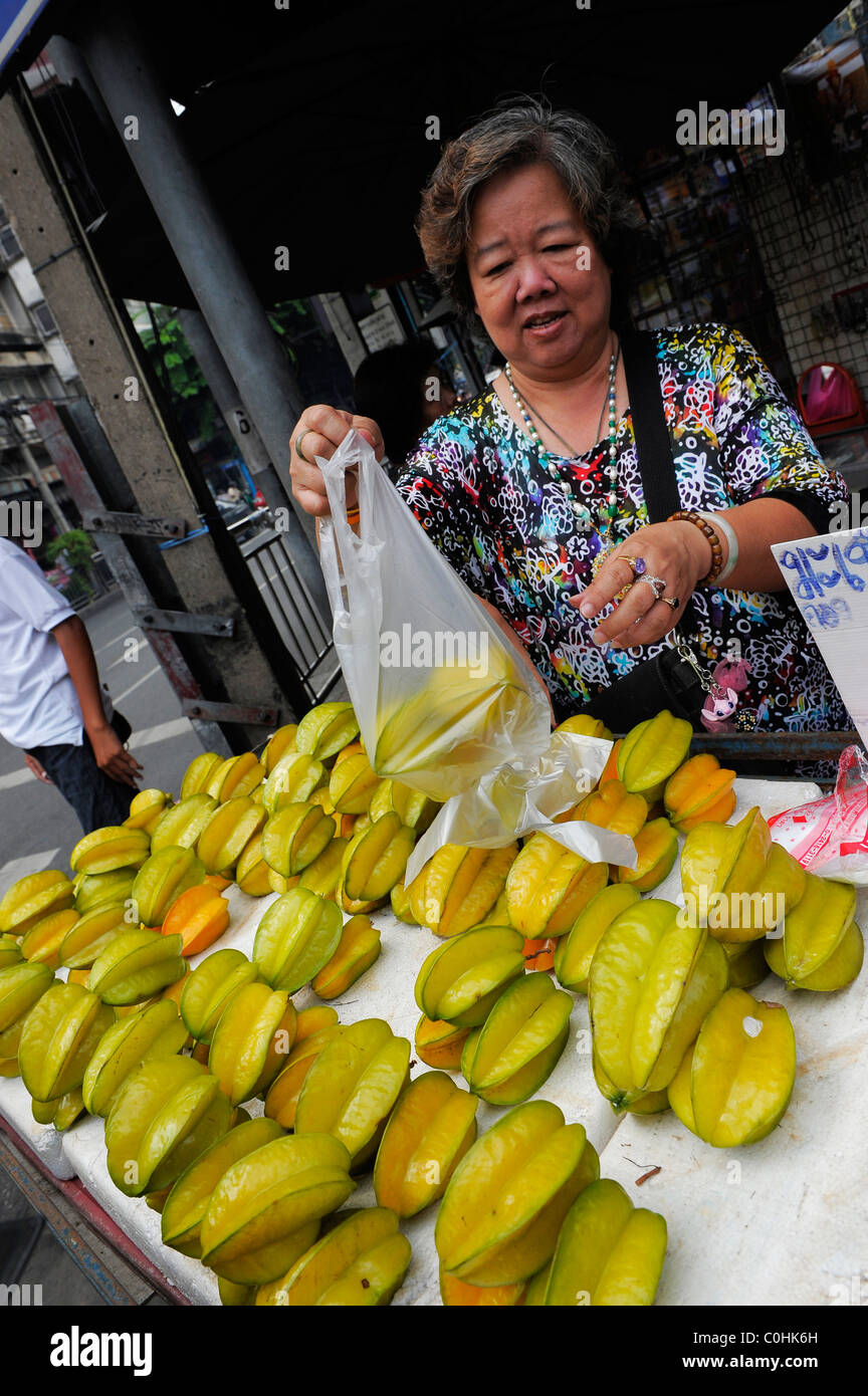 Femme chinoise vendant fruits star , chinatown , Bangkok, Thaïlande Banque D'Images