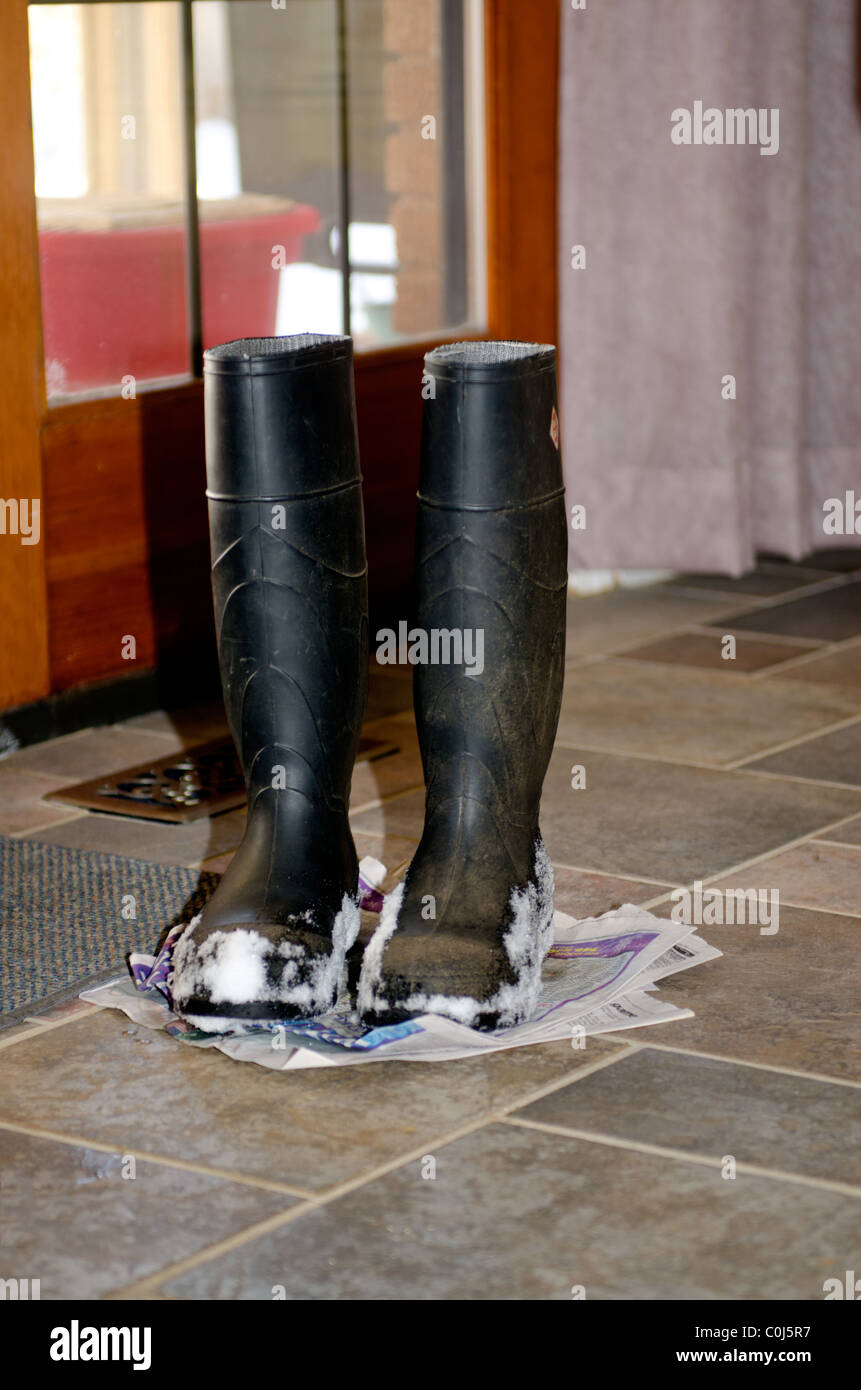 Une vieille paire de bottes en caoutchouc Balle de neige sur eux reste sur  un journal à l'intérieur. USA Photo Stock - Alamy