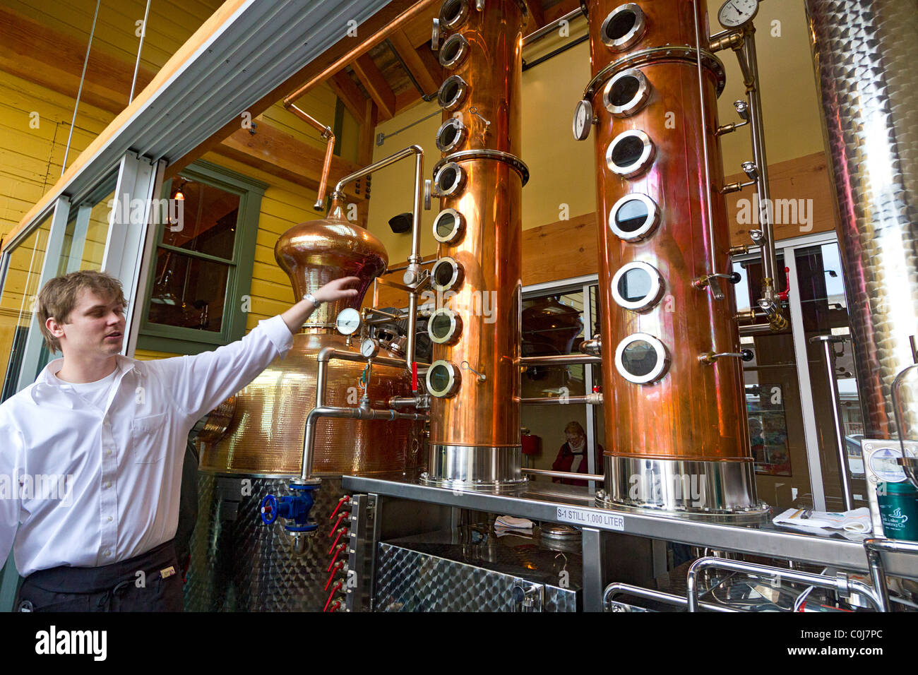 Guide parle de la production de whisky à côté de l'alambic en cuivre au cours d'une visite à la Distillerie de l'Ouest Haute & Saloon Banque D'Images