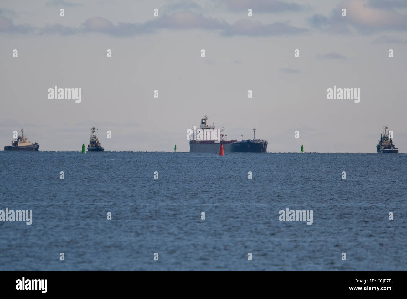 Grand navire-citerne, trois réunions à l'extérieur du port de remorqueur Banque D'Images