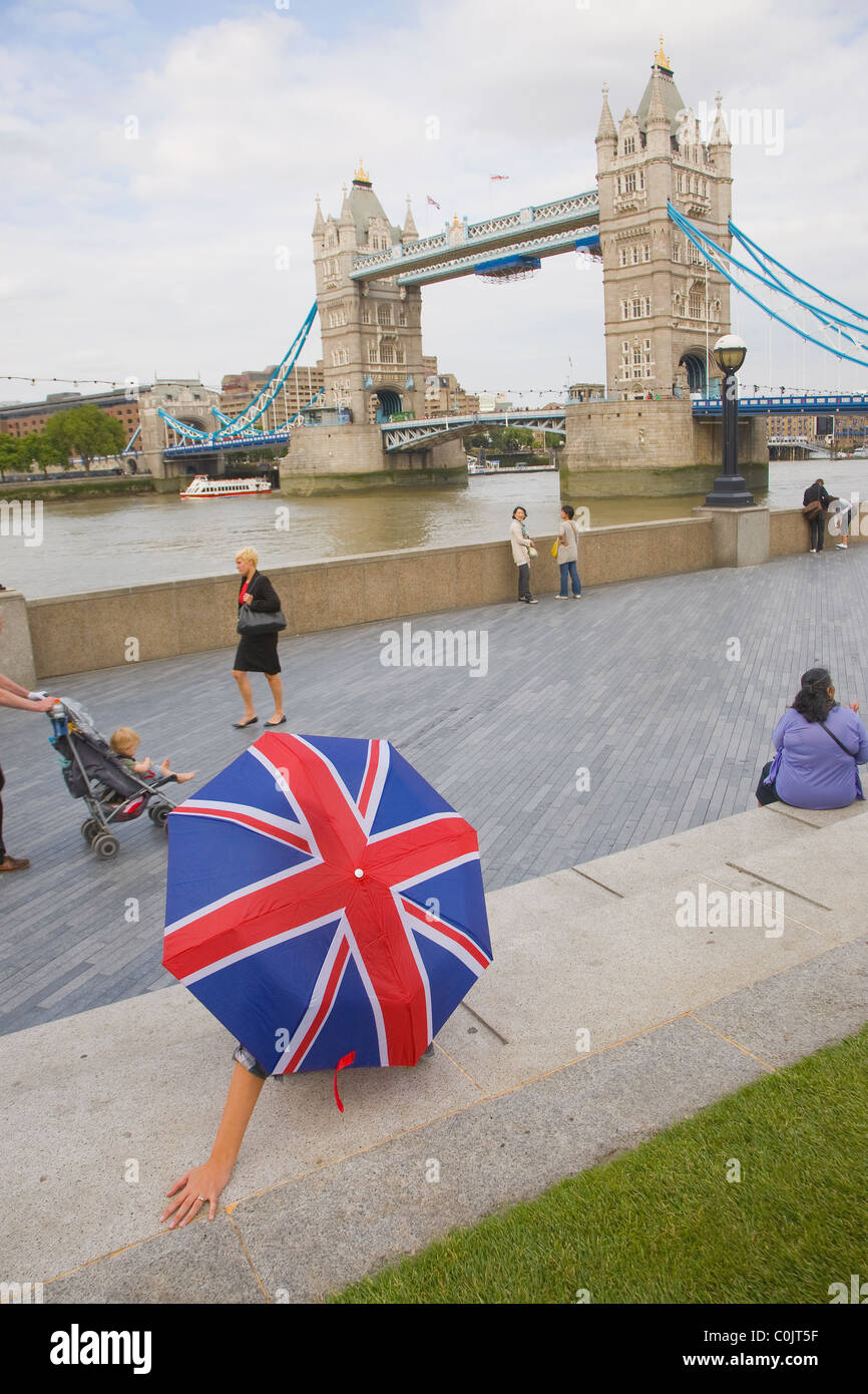 Femme avec un parapluie à l'Union Jack à la Tower Bridge Banque D'Images