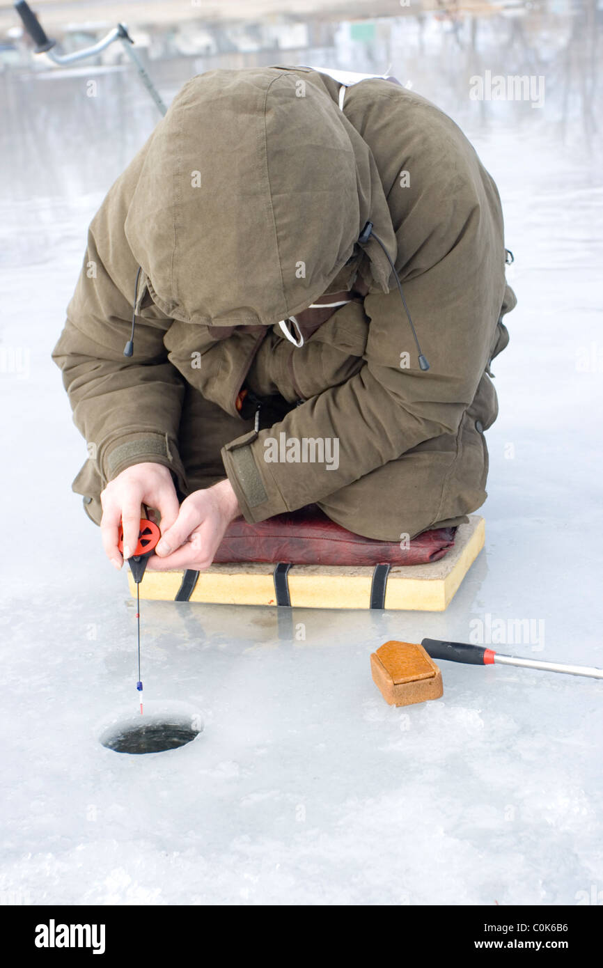 Concours de pêche sur glace. concurrent capture le poisson de pêche sur glace avec gabarit de vase Banque D'Images