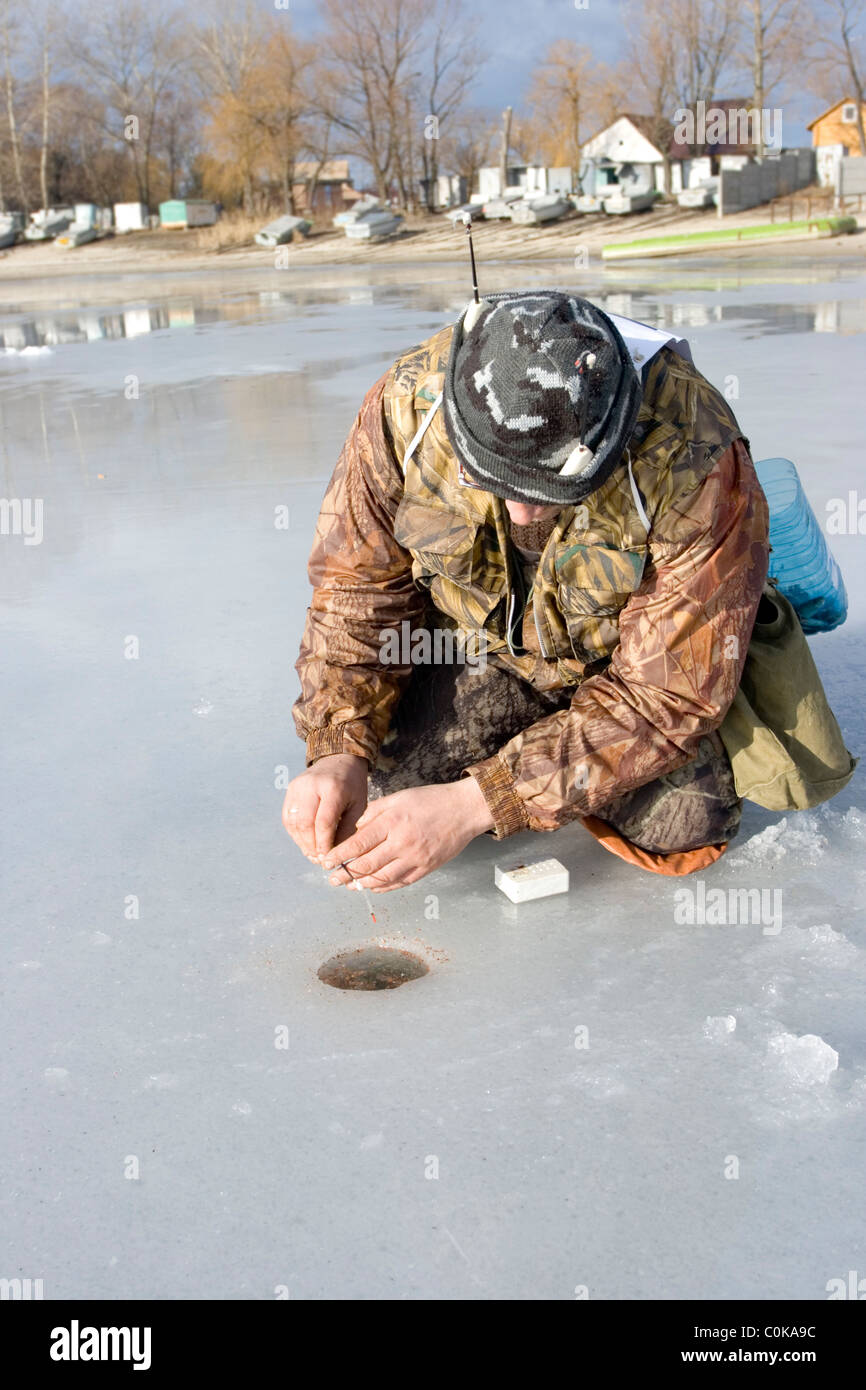 Concours de pêche sur glace. concurrent capture le poisson de pêche sur glace avec gabarit de vase Banque D'Images