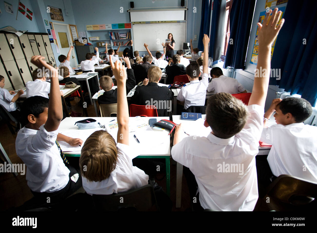 Les élèves mettent leurs mains pour répondre à une des questions à Maidstone Grammar school à Maidstone, Kent, Royaume-Uni Banque D'Images