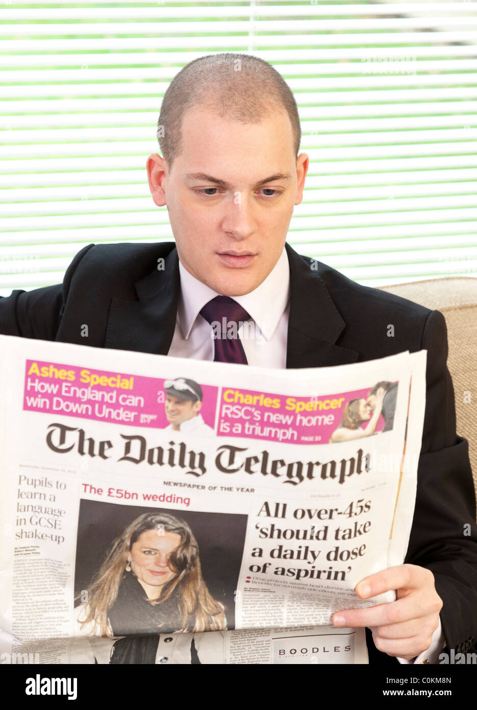 Homme lisant le journal Daily Telegraph en UK Banque D'Images