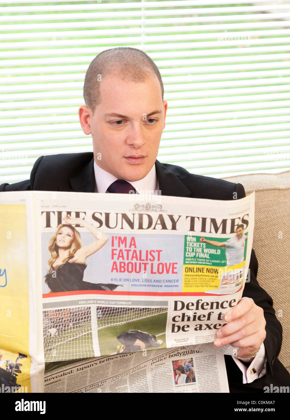 Homme lisant le journal Sunday Times au Royaume-Uni Banque D'Images