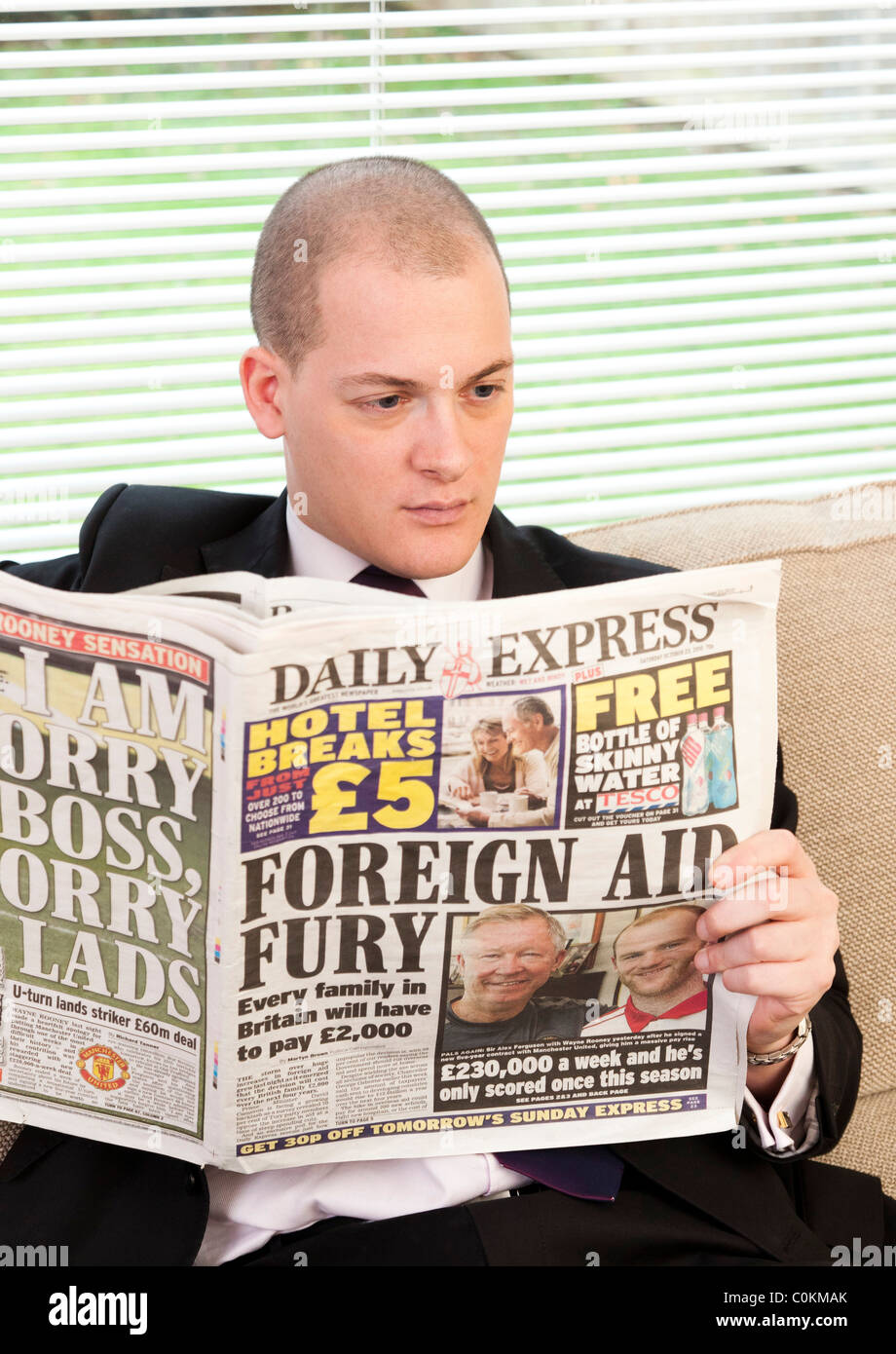 Man reading newspaper in Daily Express UK Banque D'Images