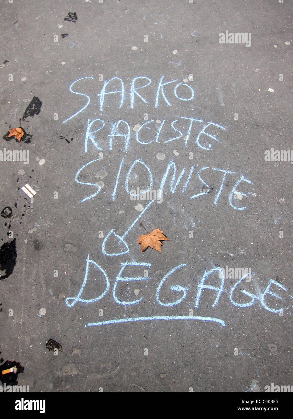 Paris, France, la craie sur trottoir Graffiti manuscrite en français 'Sarkozy, raciste, sioniste, Sortez !" Banque D'Images