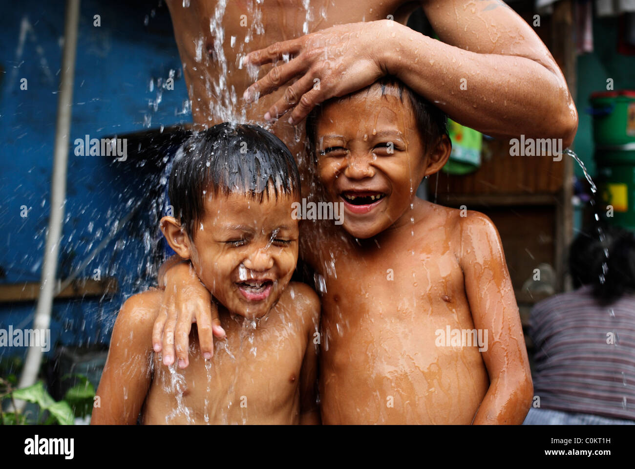 Laver les jeunes garçons dans la rue à Malate, dans Adriatico Street, Malate, Manille, Philippines. Banque D'Images