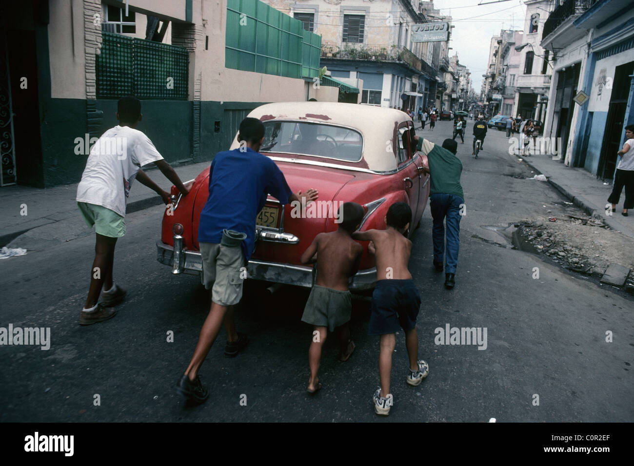 La Havane. Cuba. Les garçons poussant une vieille voiture en panne dans les rues de Centro Havana. Banque D'Images