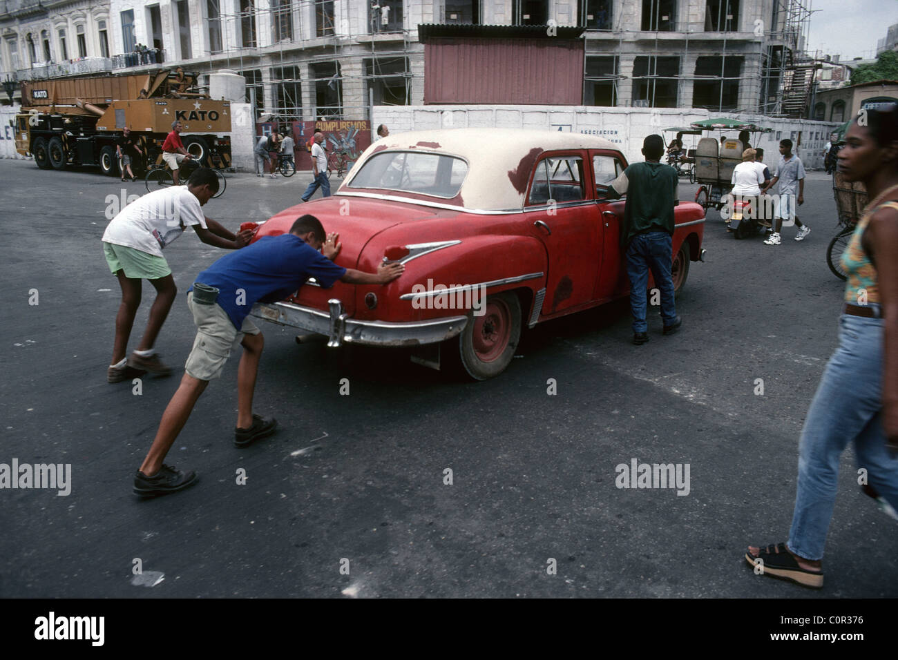 La Havane. Cuba. Les garçons poussant une vieille voiture en panne dans les rues de Centro Havana. Banque D'Images