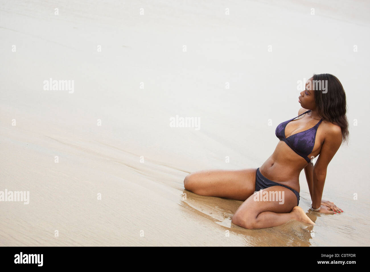 Une Jeune Femme Noire Voluptueuse Dans Un Bikini Violet Se Trouve Sur La Plage à Dakar Sénégal 